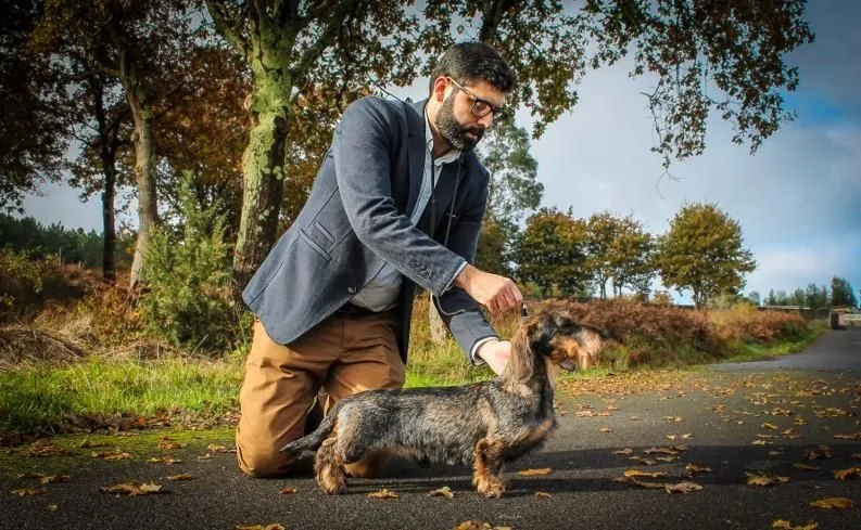 Pablo Gómez Veiras agachado xunto a Bertín nun camiño de outono